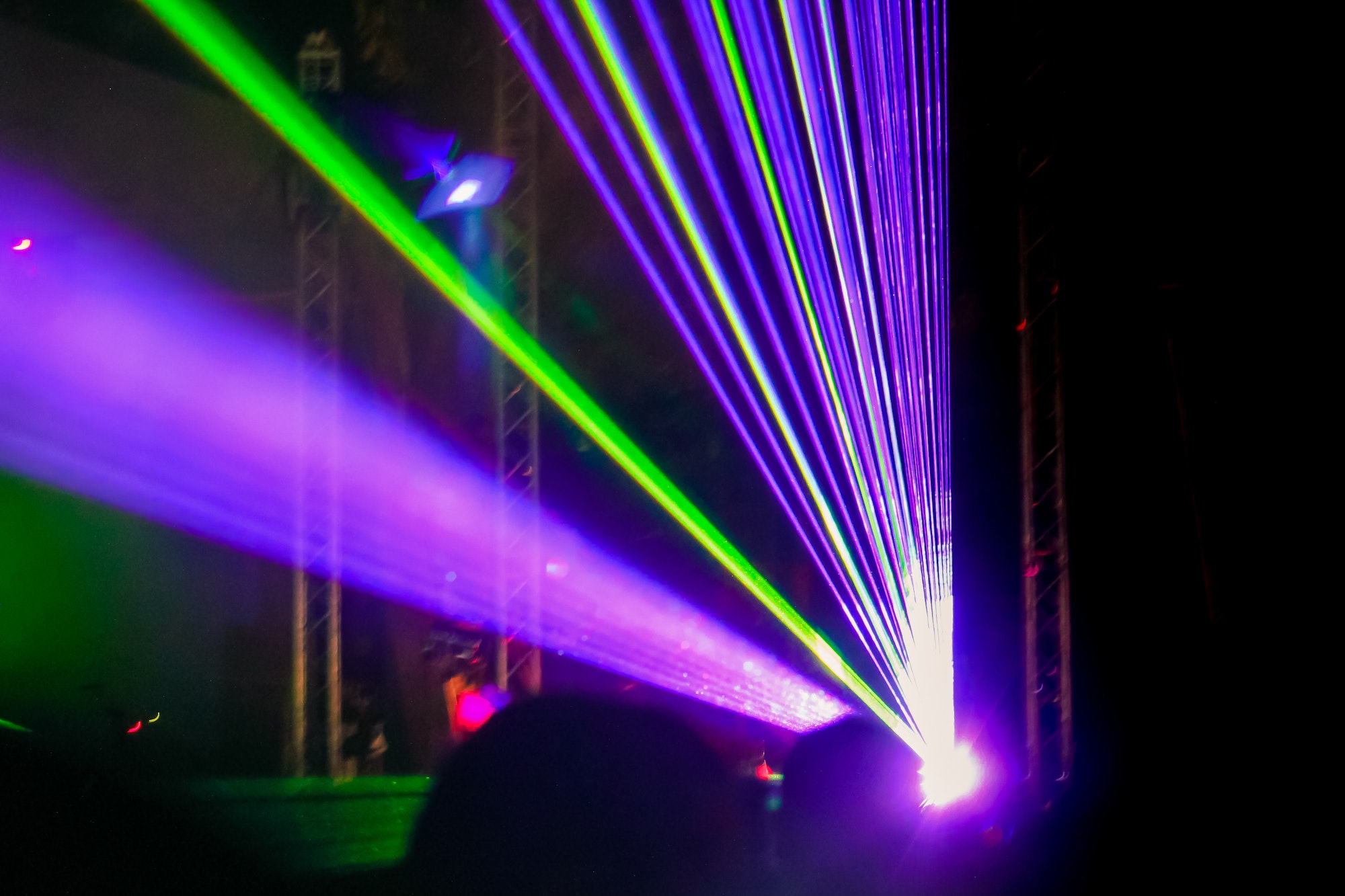 Purple laser neon beams. Crowd of people watching laser show at street festival.